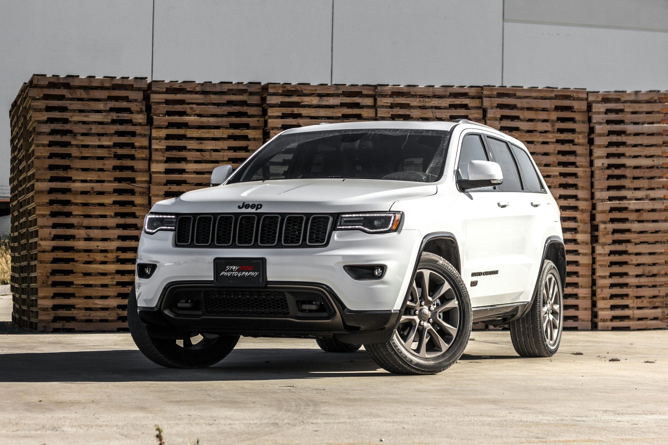 Jeep Cherokee Suv branco perto de tábuas de paletes marrons empilhadas